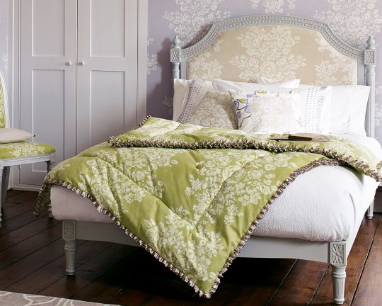 оливковое зеленой покрывало на кровати с цветами, сиреневые обои с цветами